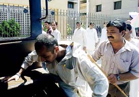 A Pakistani plainclothesman (R) arrests an agitator in front of the Karachi Stock Exchange (KSE) following a riot by furious investors in Karachi on Thursday. Law enforcement agencies were called in as around 400 small investors, who had been prevented from offloading their falling stocks, rioted at the KSE building in protest against the continued fall of the KSE-100.
