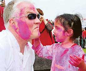 A child applies colour on a guest from the UK during Holi celebrations at Mohali Club on Friday.