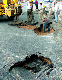 Civic agency workers repairing a damaged road in the Capital