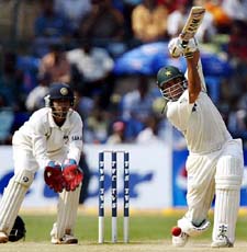 Pakistans Younis Khan plays a shot as Indian wicketkeeper Dinesh Kaarthick looks on during the fourth day of the third Test against India in Bangalore on Sunday