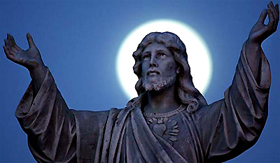 The moon appears as a halo behind a statue of Jesus at sunrise on Easter Sunday in Sydney
