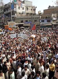 Indian traders raise their hands in protest against value-added tax, a tax reform, in the old quarters of Delhi on Tuesday