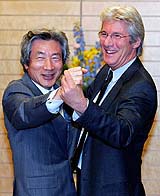 Hollywood actor Richard Gere holding the hands of Japan's Prime Minister Junichiro Koizumi prepares to dance