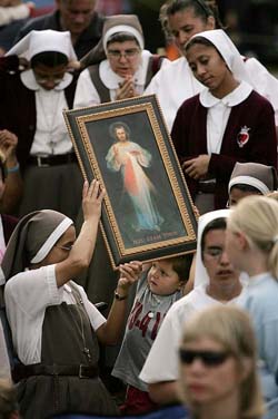 A child holds a picture of Jesus during a Mass in front of Woodside Hospice, where brain-damaged Florida woman Terri Schiavo is being cared for, in Pinellas Park, Florida
