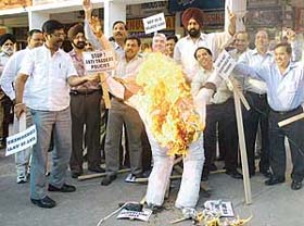 Shopkeepers burn an effigy of VAT in Sector 7, Chandigarh