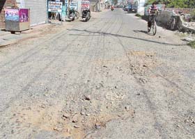 The badly broken road in a Mithapur Road colony