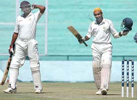 Punjabs Pankaj Dharmani acknowledges the applause after completing his century against Railways 
