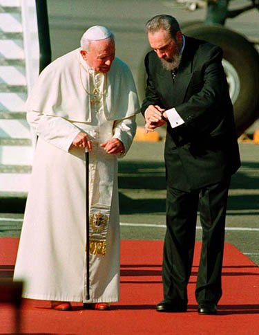 Cuban President Fidel Castro stops to show Pope John Paul II his watch as they walk to the podium during the Pope's arrival ceremony, at Jose Marti Airport in Havana on January 21, 1998