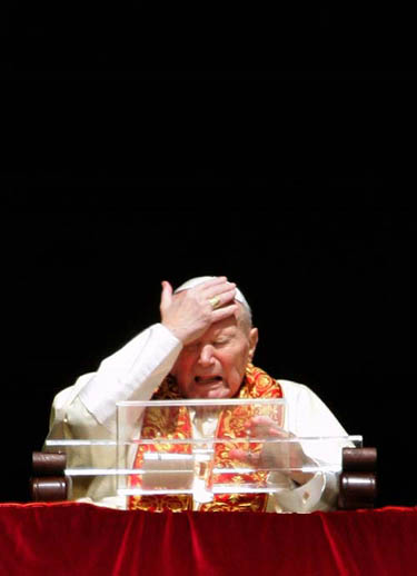 Pope John Paul II reacts as he appears from the window of his private apartments at the Vatican on March 27