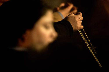 Nuns hold a rosary in front of Saint Peter's Basilica at the Vatican on March 31