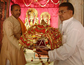 Surinder Arjun (right), working president of the Shri Durgiana Temple Committee, receives a ‘kalash’ containing holy water of Brahm Sarovar of Katasraj (Pakistan).