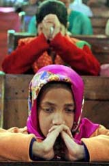 Girls mourn during a mass at a church in Srinagar on Sunday. Pope John al died on Saturday, the Vatican announced