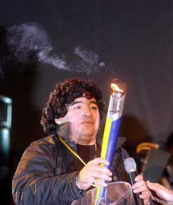 Former Argentine soccer star Diego Maradona enters the Boca Juniors stadium carrying the centennial torch as part of the 100th anniversary celebrations of the club in Buenos Aires