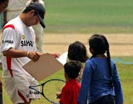 Sachin Tendulkar flips through a greeting card prepared by his young fans during a practice session on the eve of the second ODI in Visakhapatnam 