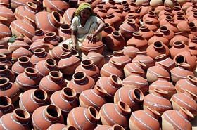 A potter gives final touches to earthen pots in Amritsar on Tuesday