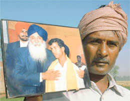 A Bihari landowner displays a picture of Mr Parkash Singh Badal honouring a farmer with a siropa.