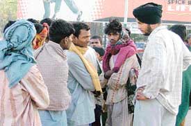 A farmer discusses terms with migrant labourers at the Ludhiana railway station before engaging them for the harvesting of wheat