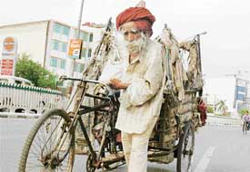 Burdened with age, the old man cannot cast off his burdens and continues to trudge on with a heavy heart in a city street