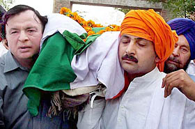 Vijay Inder Singla carries the body of his father, Sant Ram Singla, at the cremation ground in Patiala on Friday.