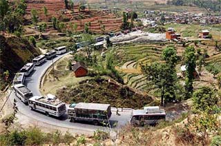 Trucks and buses lineup in a convoy to be escorted by the army at the main highway at Khanikhola