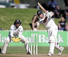 Lou Vincent of New Zealand hits a shot as Kumara Sangakkara of Sri Lanka looks on during the second days play of the second Test in Wellington