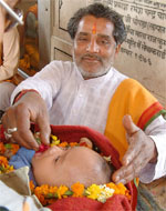 A newly born child being given drops of holy water during the Baisakhi celebrations at Durgiana Temple on Wednesday.
