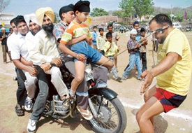 Bahadur Khan of Malerkotla pulls a motor cycle carrying six persons at the rural sports mela held at Khuda Ali Sher Village, near Chandigarh, on Thursday. 