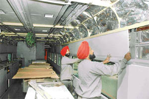 Workers fixing sleek panels inside a rail car