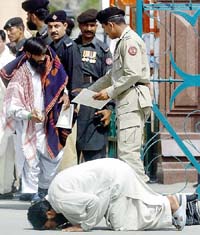 A Pakistani national touches his forehead on the ground after crossing over at the Wagah checkpost on Thursday. He was among the Pakistani prisoners released from a jail in Amritsar.