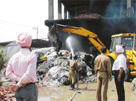 Fire-fighters work with a debris-removal team of the MC at Supreme Woollen Mills, Kanganwal, near Ludhiana, which was destroyed in fire on Thursday