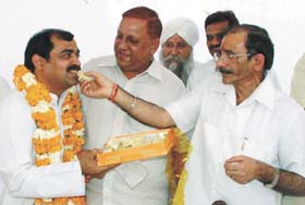Jitendra Kochar being offered sweets by DPCC president Ram Babu Sharma in the Capital
