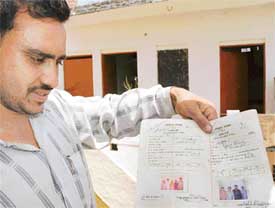 Mr Ram Nath, son of Mr Dharam Pal of Saketri village, in Panchkula, shows the ration cards containing names of nine members of his family living in the house that allegedly has 111 voters