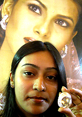 A girl holds up a replica of the world famous Kohinoor diamond kept for sale at a diamond and mega jewellery exhibition in Bhopal on Sunday.