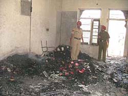 Policemen supervise a classroom of a school in Ludhiana which was burnt by mob following the death of a student.