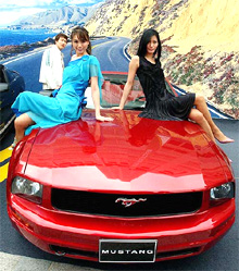 South Korean models pose with Fords new Mustang during a press unveiling in Seoul on Monday
