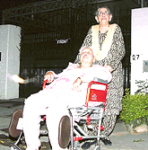 Beant Kaur (on wheelchair) and Satwant Kaur outside their house.