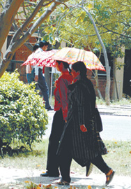 Two students carrying umbrellas to save themselves from the scorching sun in the Capital on Thursday.