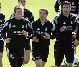 David Beckham  and Michael Owen of England run with their Real Madrid team-mate Luis Figo of Portugal during a training session in Madrid on Tuesday