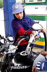 A saleswoman fills petrol at a petrol station in Srinagar on Wednesday