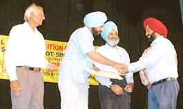 Prof Kanwaljit receives an award for photography from MP Navjot Singh Sidhu. 