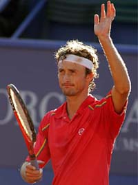 Juan Carlos Ferrero waves to the crowd after defeating Marcos Baghdatis of Cyprus in their first round match at the Estoril Open in Portugal