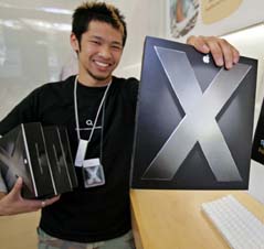 Apple Computers Inc. salesman Brian Tong holds up an advance copy of the latest update of the Mac OS X dubbed Tiger at the Apple Store in Palo Alto, Calif., on Wednesday. The much anticipated sale starts today.