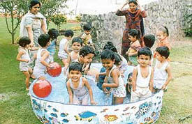 Nursery students of Shishu Niketan Public School, Mansa Devi Complex, Panchkula, enloy a cool dip in a splash pool while teachers tell them about water life on Friday.