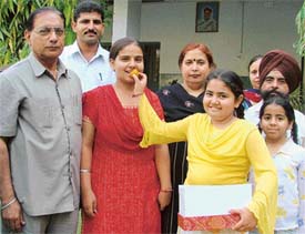 Jasmeet Kaur shares sweets with her family and Principal M.L. Kalra