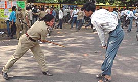 A lady police officer beats up a student