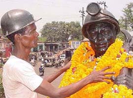 A labourer garlands the Statue of Mine Labourer on the occasion of International Labour Day
