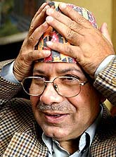 Madhav Kumar Nepal, chief of the Communist Party of Nepal-UML, adjusts his hat after a press conference held after his release from house arrest in Kathmandu on Monday