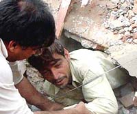 A wounded survivor is taken out of the wreckage of a three-story building which collapsed in Lahore on Tuesday