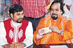 Magician O.P. Sharma (in orange outfit) shows one of his magic tricks at a press conference in Ludhiana