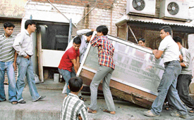 Shopkeepers remove goods from a corridor of Sector 7 market after HUDA launched an anti-encroachment drive in Panchkula on Friday evening.